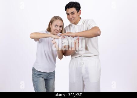 Giovane uomo e donna che mostrano un gesto cardiaco con le mani Foto Stock