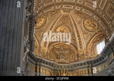 Interno della Basilica di San Pietro, città del Vaticano. Dettagli in stucco in oro barocco e iscrizioni latine all'interno dell'iconica chiesa cattolica. Foto Stock