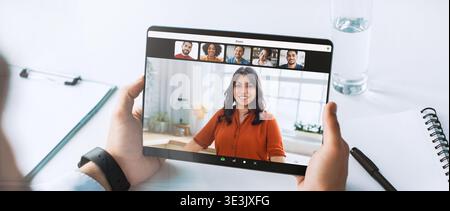 Il medico si impegna in una consulenza online durante il blocco Covid-19 che lavora in remoto dalla sua scrivania Foto Stock