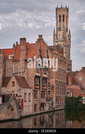 Vista di Rozenhoedkaai con edifici storici e la torre del campanile che si riflette nel canale di Bruges, Belgio Foto Stock