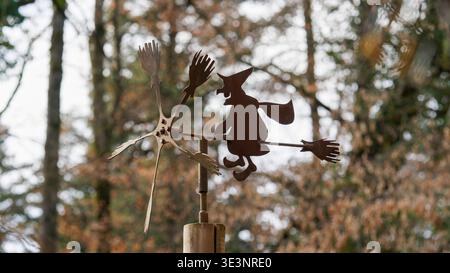 Stravagante Flying Witch Weathervane: Giocosa silhouette in metallo che gira nella foresta autunnale Foto Stock