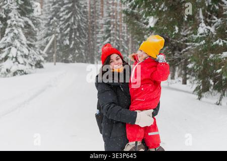 Madre e figlia bambina in inverno in una foresta innevata Foto Stock