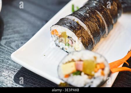 Il kimbap, un vibrante piatto coreano informale, è caratterizzato da appetitose composizioni e primi piani dinamici, che mostrano le sue diverse e colorate ripieni Foto Stock