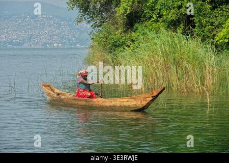 Donna che pagaia sul lago Kivu, Cyangugu (Rusizi), Ruanda Foto Stock