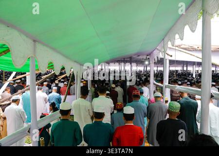 Le persone si sono riunite presso l'Eidgah nazionale di Dacca il 21 marzo 2026 per offrire preghiere Eid, abbracciando e scambiando in occasione di celebrazioni. Foto Stock