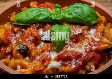 Gli gnocchi alla sorrentina sono gnocchi di patate conditi con una semplice salsa di pomodoro aromatizzata al basilico, arricchiti con mozzarella e parmigiano, e t Foto Stock
