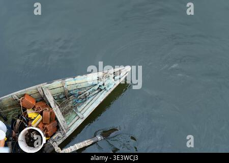 Hoi An, Vietnam - marzo 2026: Vista dall'alto della barca da pesca in legno con pescato e attrezzature sul fiume durante l'attività di pesca quotidiana Foto Stock
