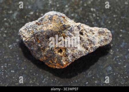 Foto macro di uno psilomelano grezzo di roccia minerale naturale (minerale di manganese) su sfondo di granito scuro Foto Stock