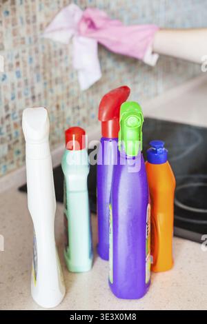Bottiglie di plastica per la pulizia della casa con prodotti per la pulizia sul piano di lavoro della cucina Foto Stock