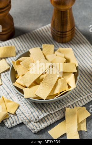 Asciugare gli spaghetti organici larghi in una ciotola per cuocere la zuppa Foto Stock