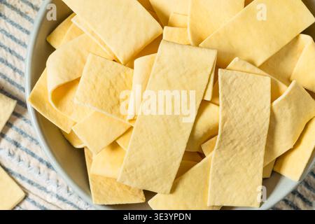 Asciugare gli spaghetti organici larghi in una ciotola per cuocere la zuppa Foto Stock