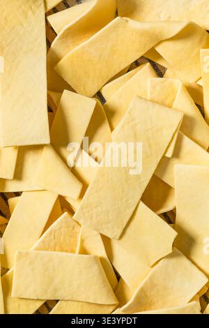 Asciugare gli spaghetti organici larghi in una ciotola per cuocere la zuppa Foto Stock