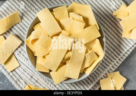 Asciugare gli spaghetti organici larghi in una ciotola per cuocere la zuppa Foto Stock