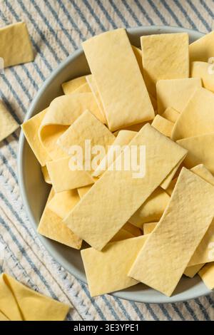 Asciugare gli spaghetti organici larghi in una ciotola per cuocere la zuppa Foto Stock