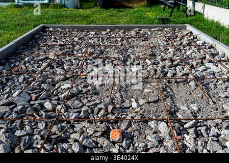 Cordoli di cemento che circondano una griglia di armature su una base di macerie per una nuova base Foto Stock