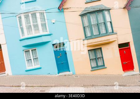 Case colorate su una strada inclinata con finestre e porte Foto Stock