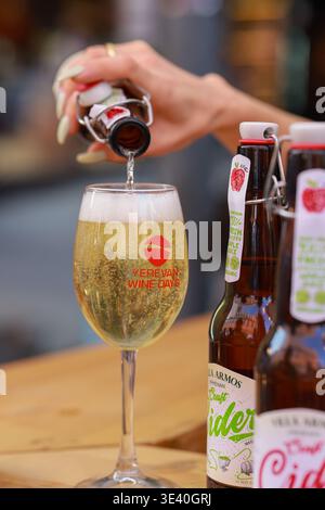 Durante il festival, a Yerevan, in Armenia, viene versata una bevanda bianca frizzante in un bicchiere di marca Foto Stock