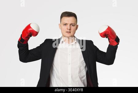 Uomo d'affari in guanti da boxe flesso bicipiti Foto Stock