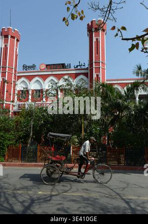 Un risciò in bicicletta di fronte alla stazione ferroviaria di Delhi nella vecchia Delhi, in India. Foto Stock