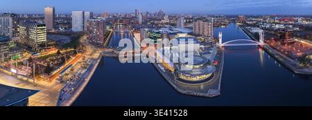 Un'ampia vista aerea panoramica del centro artistico Lowry e del Millennium Footbridge che attraversa il Manchester Ship Canal a Salford Quays al crepuscolo. Foto Stock
