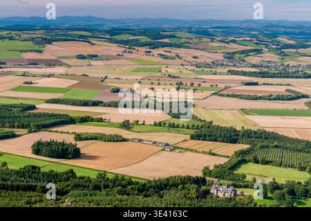 Ampia vista aerea sull'Howe of Fife che mostra terreni coltivabili, campi di patchwork, boschi sparsi e un villaggio lontano all'interno del Rolling SC Foto Stock