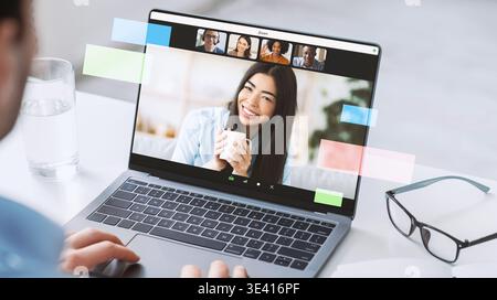 Man partecipa a una conferenza online e si impegna con i colleghi sul notebook Foto Stock