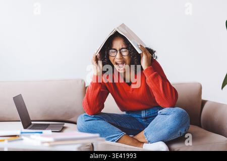 Mi sento sopraffatto mentre studia a casa in un pomeriggio tranquillo Foto Stock