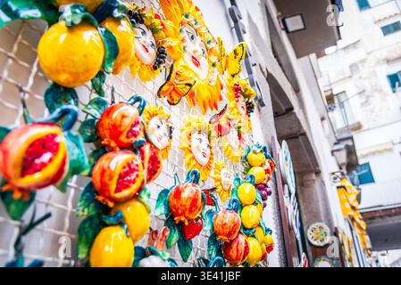 Amlfi, Italia. Vivaci ceramiche e limoni su una tradizionale parete di negozi, la Campania. Foto Stock