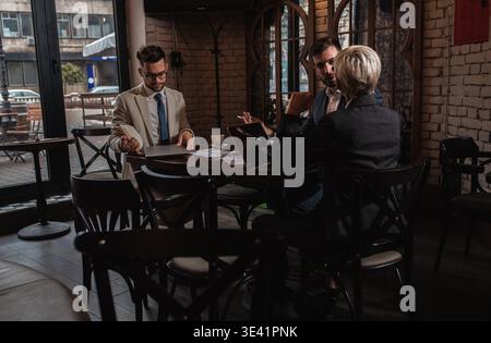 Gruppo di uomini d'affari che hanno una riunione alla caffetteria dell'ufficio. Foto Stock