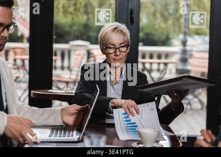 Gruppo di uomini d'affari che hanno una riunione alla caffetteria dell'ufficio. Foto Stock