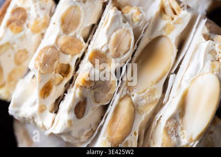 Uno scatto ravvicinato cattura splendidamente una pila di turroni duri spagnoli tradizionali, noti come Turron de Alicante, mostrando la sua ricca consistenza con abbondanza Foto Stock