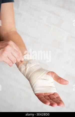 Uomo con bendaggio elastico per avvolgere le mani, copertura per polsi con bendaggio. Sindrome del tunnel carpale dolore al polso, lesioni sportive, infiammazione tendinica o artrito Foto Stock
