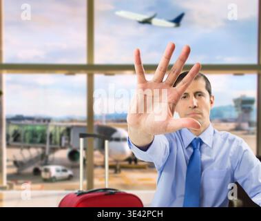 Uomo d'affari che mostra la mano ferma nella sala partenze dell'aeroporto Foto Stock