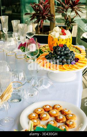 Elegante brunch all'aperto con frutta di stagione e bevande frizzanti Foto Stock