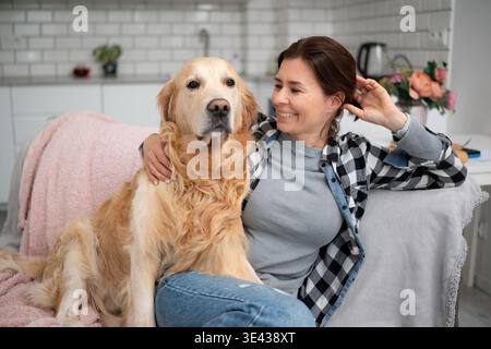 Happy Girl at Home, sorridente e avvolgente adorabile Golden Retriever Dog Foto Stock