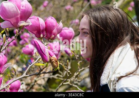 Donna che ama i fiori di ciliegio in un tranquillo giardino giapponese. Delizia della fioritura. Foto Stock