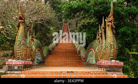 Wat Phra That Doi Suthep, Chiang mai, Thailandia - 16 marzo 2020: I visitatori camminano lungo la scalinata fiancheggiata da naga che conduce al tempio. Foto Stock
