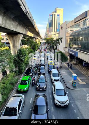 Ingorgo di traffico pesante su Bangkok City Road sotto la sopraelevata BTS Skytrain Foto Stock
