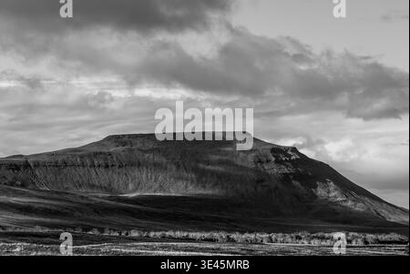 Paesaggio monotono della cima piatta di Ingleborough con ripidi pendii rocciosi e calci sotto un cielo spettacolare Foto Stock