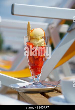 Fragole fresche con gelato in bicchiere, dessert estivo, cibo dolce, dolcetto rinfrescante e concetto di stile di vita nel Beach Cafe estivo Foto Stock