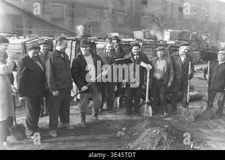 Sloviansk, aprile 1989, cantiere AIZ. L'allegro team di gestione della fabbrica posa con orgoglio per un ritratto di gruppo che tiene spatole pesanti durante una tradizionale giornata di pulizia volontaria del subbotnik primaverile. Indossando un pratico abbigliamento da esterno, questi uomini dedicati sorridono calorosamente per la fotocamera dopo aver lavorato insieme per liberare il cortile industriale da sporcizia e detriti. Questa immagine altamente positiva racchiude perfettamente la genuina cameratismo, l'uguaglianza e le tradizioni lavorative condivise nel pacifico Donbas. Foto Stock