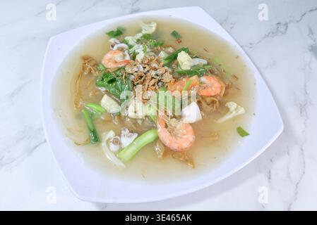 Una foto professionale dall'alto di Kuey Teow Ladna con spaghetti di riso piatti inzuppati in una salsa a base di uovo setoso. Ricoperto di gamberi freschi, calamari, caul Foto Stock