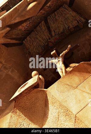 Facciata della Sagrada Família Passion, Barcellona: Spettacolare vista angolata della scultura della crocifissione in pietra sull'esterno in arenaria con coloratissimi dettagli a mosaico. Foto Stock