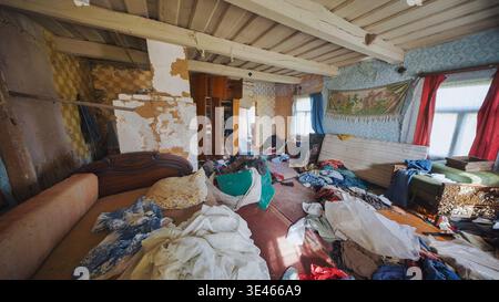 Camera abbandonata che mostrava un enorme accumulo e disordine all'interno di una vecchia casa trascurata Foto Stock