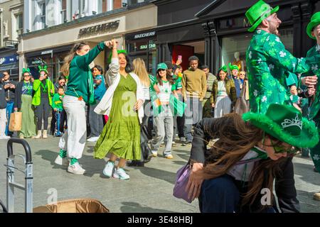 Danze di strada spontanee durante la parata del giorno di St Patricks nel centro di Dublino. Folle festose in Irlanda Foto Stock