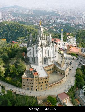 Veduta aerea del Tempio Expiatori del Sagrat Cor sulla collina del Tibidabo con persone che visitano il parco divertimenti e lo skyline della città di Barcellona, Catalogna, Foto Stock
