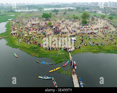 Vista aerea di un vivace raduno sulle lussureggianti rive verdi di dia Bari Road con barche che costellano l'acqua, Dacca, ঢাকা বিভাগ, Bangladesh. Foto Stock