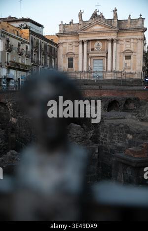 Vista delle antiche rovine del Teatro Romano con la storica Chiesa di San Biagio sullo sfondo sotto un cielo limpido a Catania, Sicilia, Italia. Foto Stock