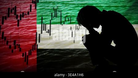 Concetto di crisi finanziaria e recessione economica negli Emirati Arabi Uniti. Sagoma di un uomo stressato con grafici del mercato azionario e candelieri sopra la bandiera dello United Foto Stock