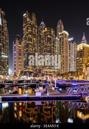 Skyline notturno di Dubai Marina con grattacieli illuminati e lussuosi riflessi sul lungomare, Emirati Arabi Uniti Foto Stock